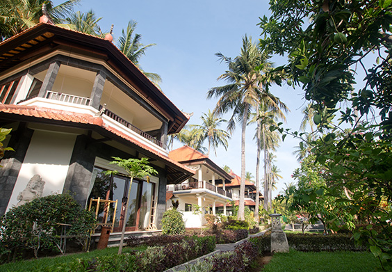 Exterior of a villa with lush garden and palm trees