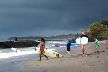 Tourists walking along the Canggu beach shore