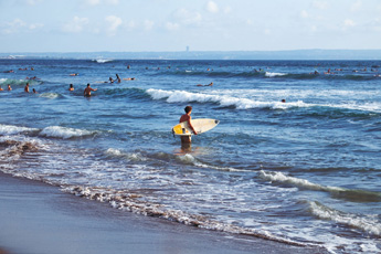 Surfers riding waves on a blue ocean beach