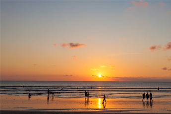People walking on the beach during a vibrant sunset