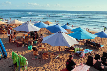 Beachfront dining tables with umbrellas