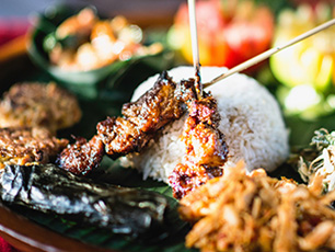 Grilled meat and rice served on banana leaf