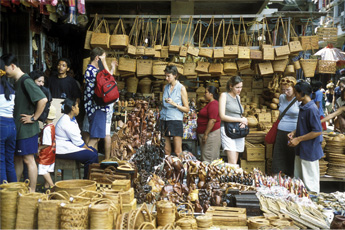 Tourists shopping for wooden carvings at a local market