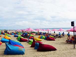 People relaxing on bright bean bags on beach