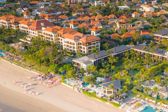 Aerial view of beachside resort with pool and buildings