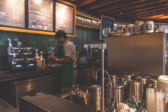Barista making coffee in a rustic café interior