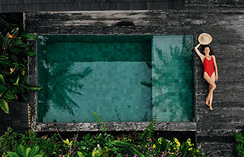 Woman relaxing in pool at luxury beachfront resort