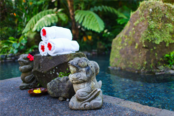 Outdoor spa setup with white towels and stone sculptures