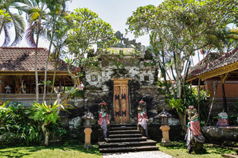 Traditional Balinese palace entrance surrounded by tropical trees