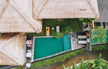 Private villa courtyard with green pool and traditional roof